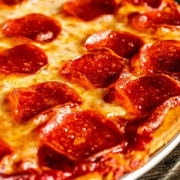 Close-up of a freshly baked pepperoni pizza with melted cheese and crispy crust.